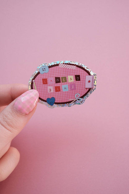 Clever girl sticker held in hand, oval fabric design with letter tiles and bow