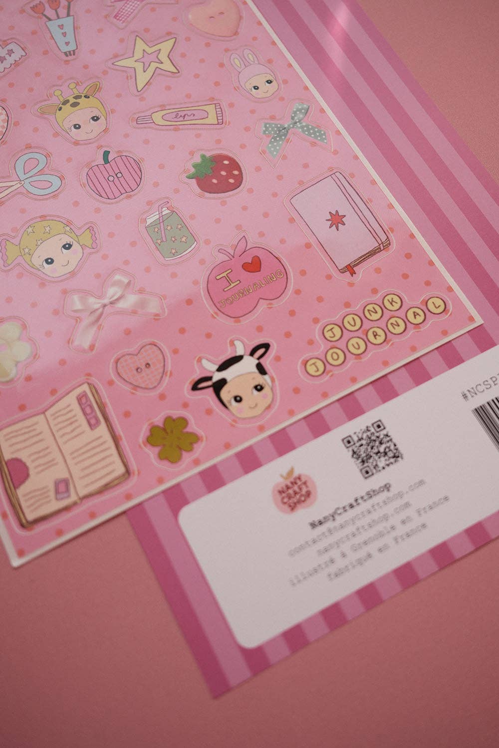 Pink A5 sticker sheet with hearts, books, stars, strawberry icons, and barcode card