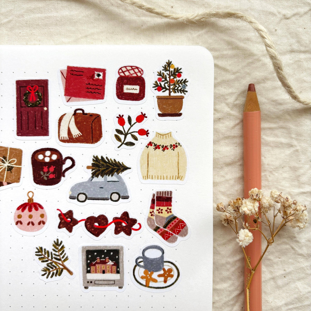Winter sticker sheet close-up with ornaments, gift boxes, holly, and a small car icon.