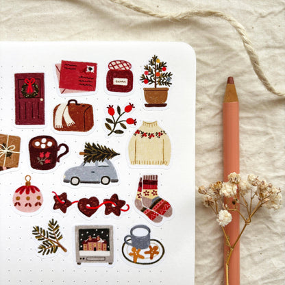 Winter sticker sheet close-up with ornaments, gift boxes, holly, and a small car icon.