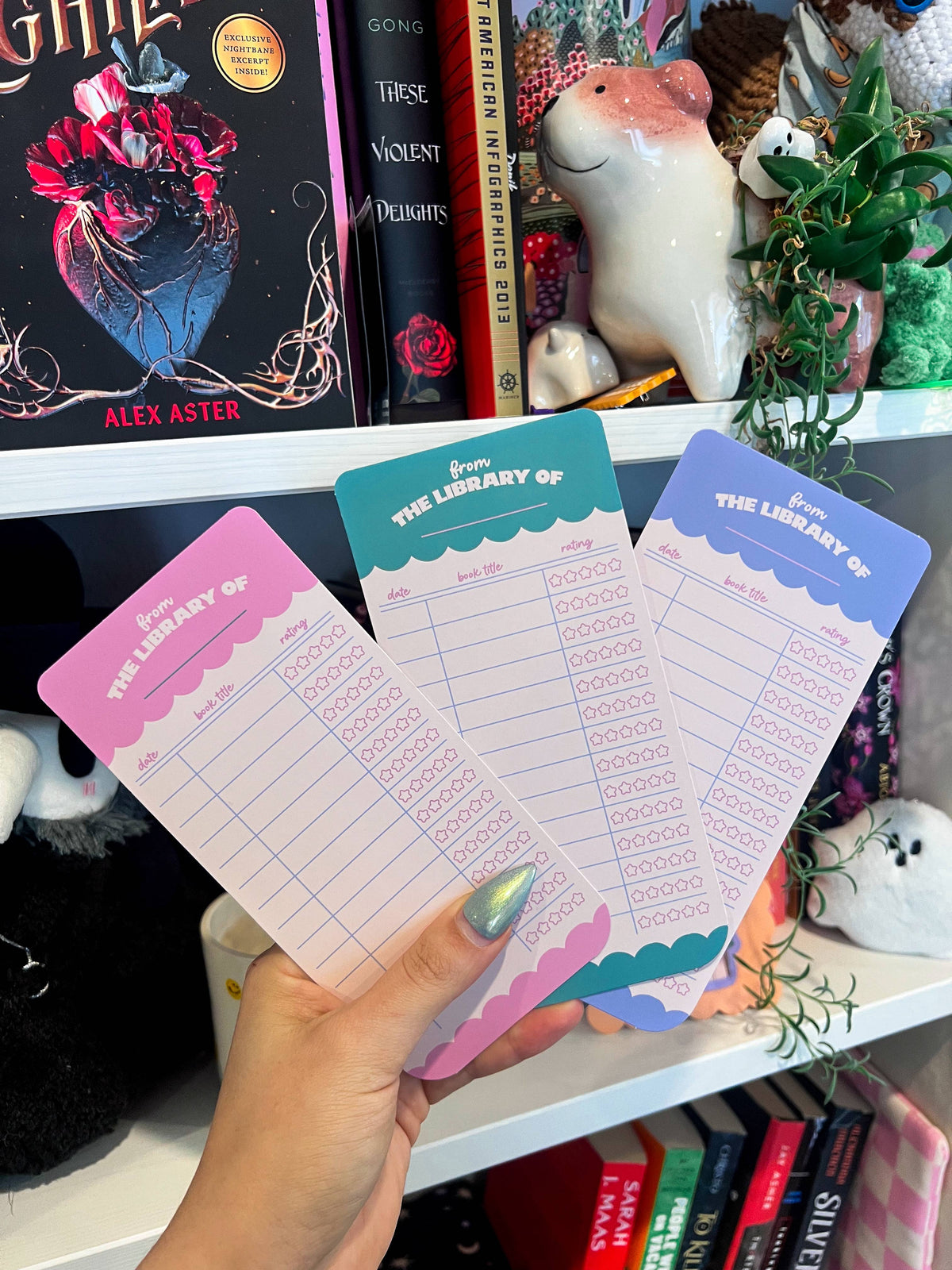 Set of pink paper bookmarks with teal header and rating icons in a lined grid