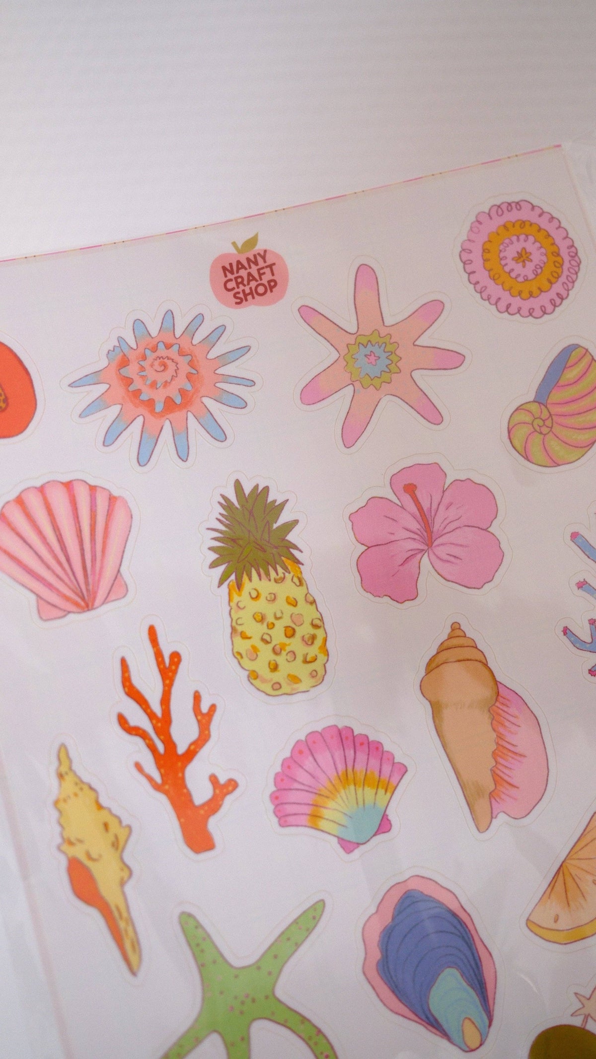A5 sticker sheet close-up with bright seashells, starfish, pineapple and floral icons