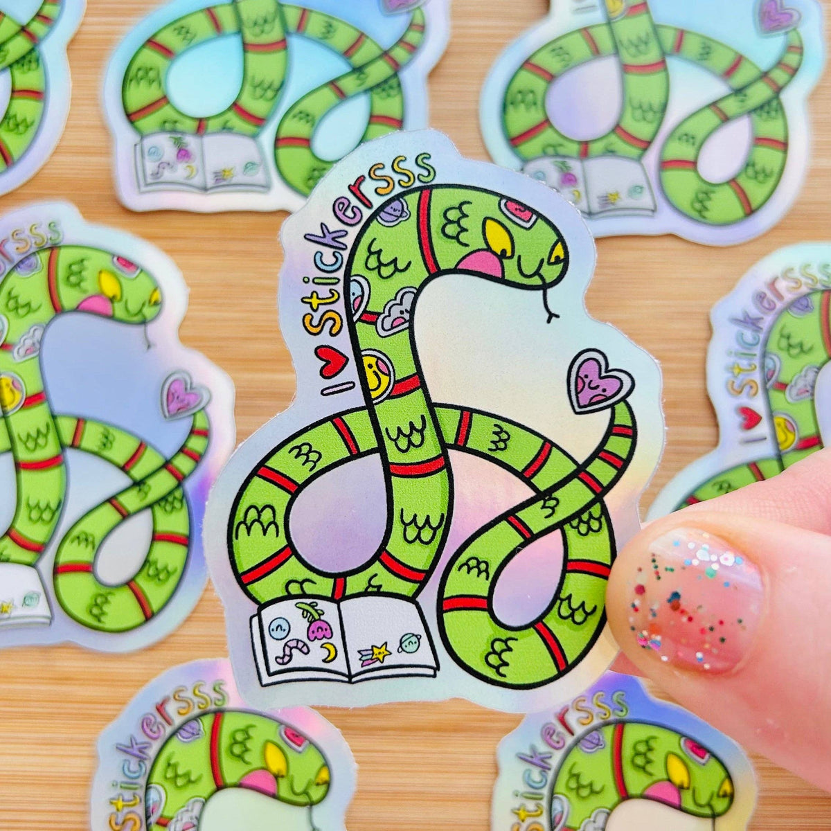 Rainbow holographic snake sticker, green cartoon serpent with hearts and Stickerss text
