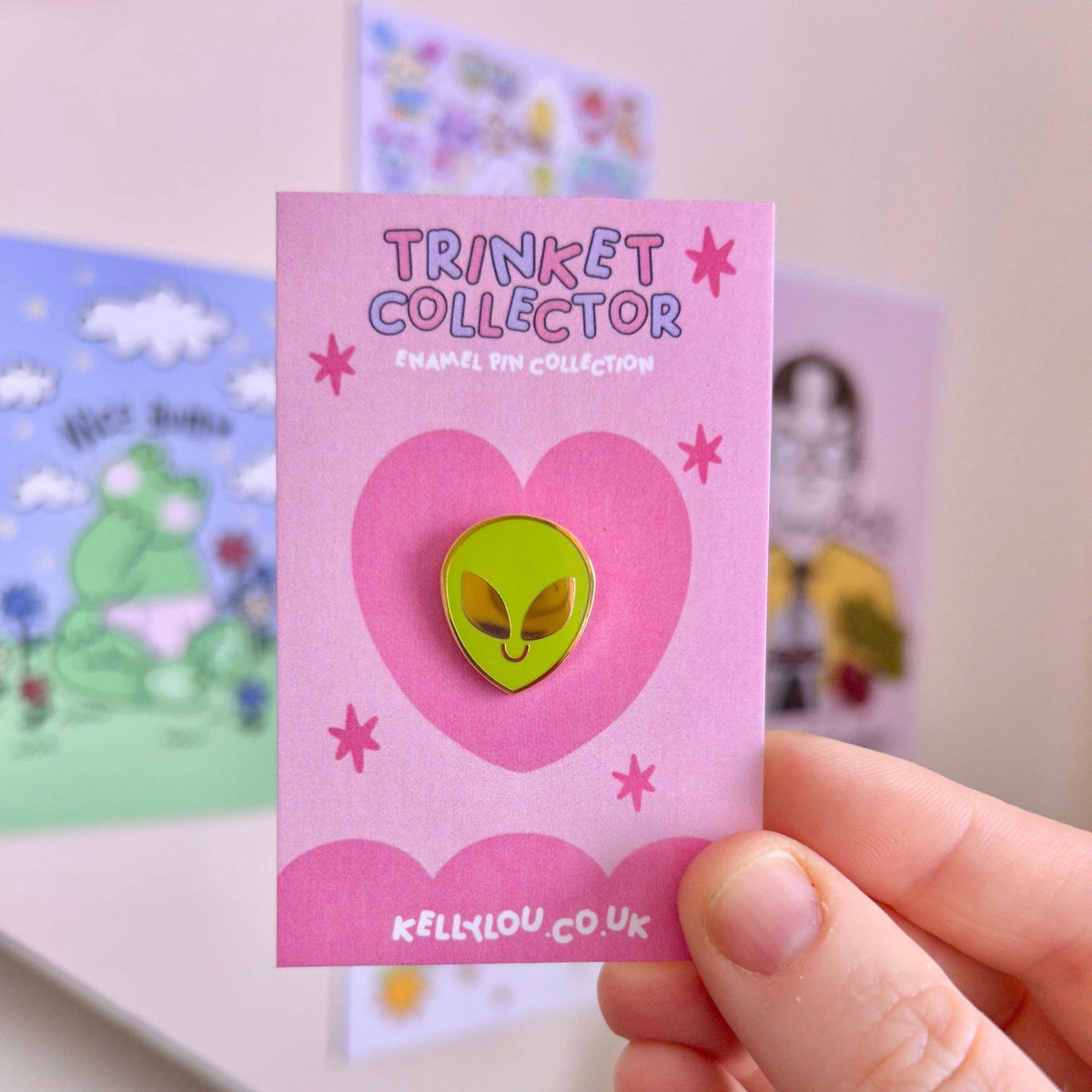 Alien head mini enamel pin on pink card, green face with yellow border