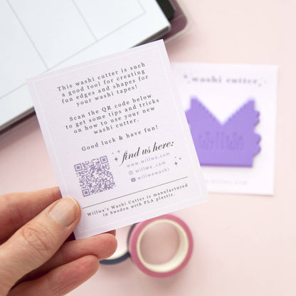 Hand holding a “washi cutter” instruction card beside a purple house-shaped cutter