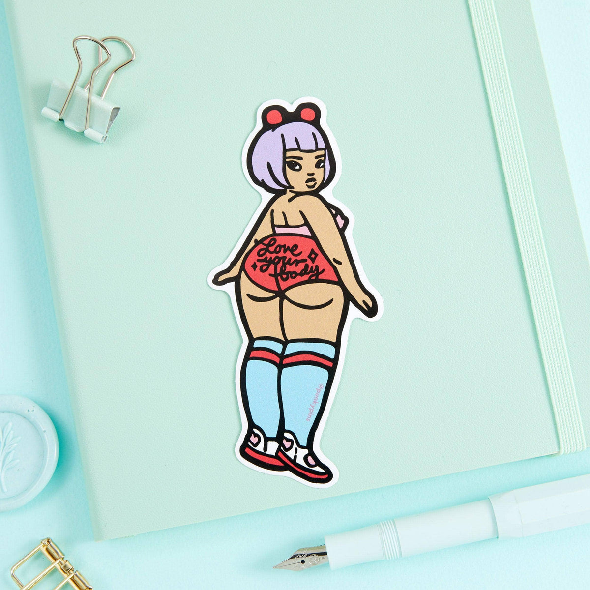 Cartoon vinyl sticker of a stylized woman in a red top and blue striped shorts