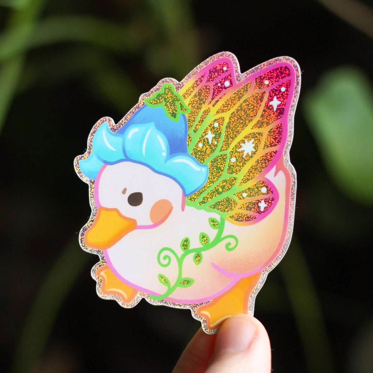 Fairy duck vinyl sticker of a cartoon duck with teal head, colorful wings, sparkly border