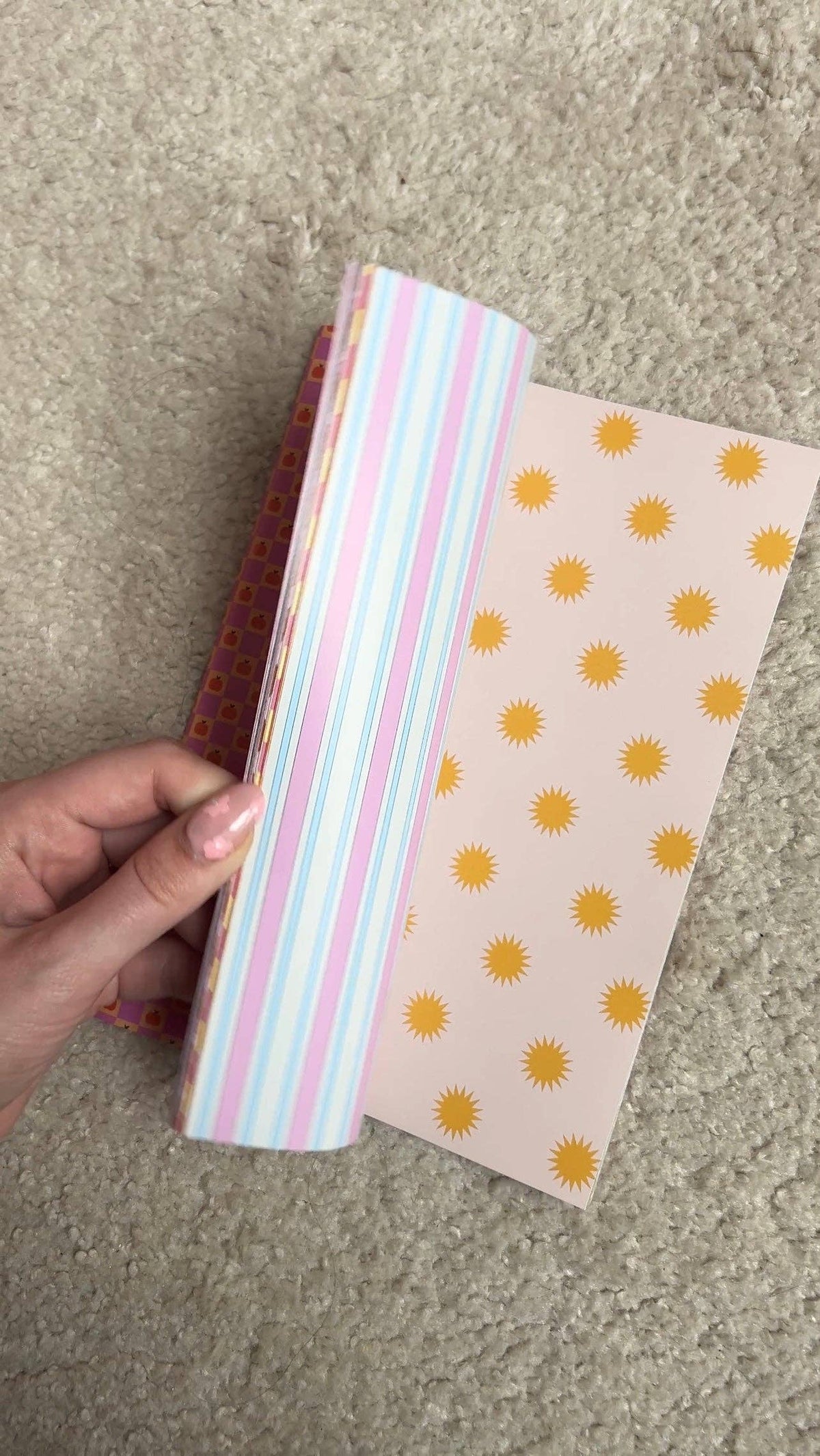 Open scrapbook paper, pink-blue stripes on left and yellow sun icons on right