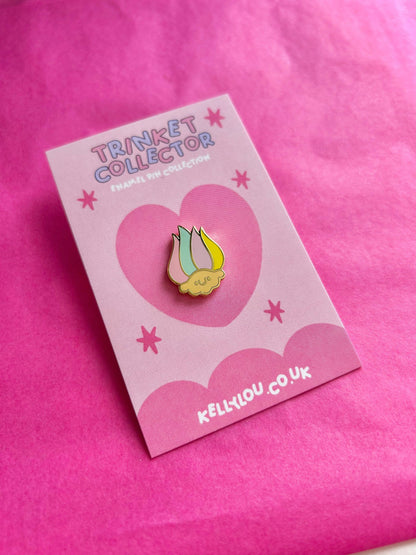 Mini troll head enamel pin, yellow face with green-striped hat, on pale card