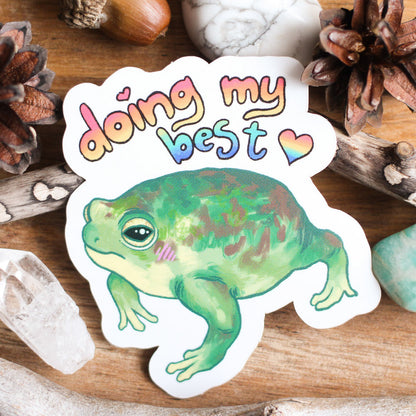 Vinyl sticker: 'Doing my best' lettering with green frog illustration on white backing.