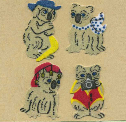 Sticker roll of fuzzy koala stickers, four cartoon koalas in hats and scarves