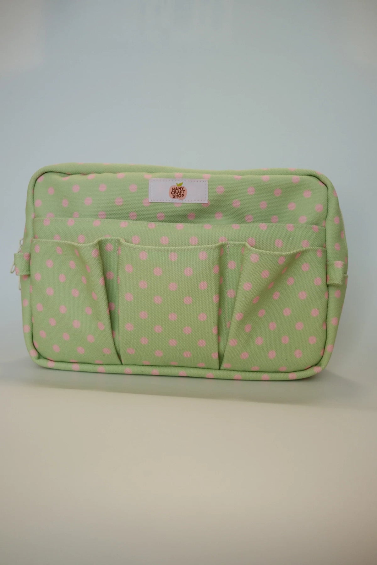 Green polka dot crafting pouch with central logo patch and stitched panel details