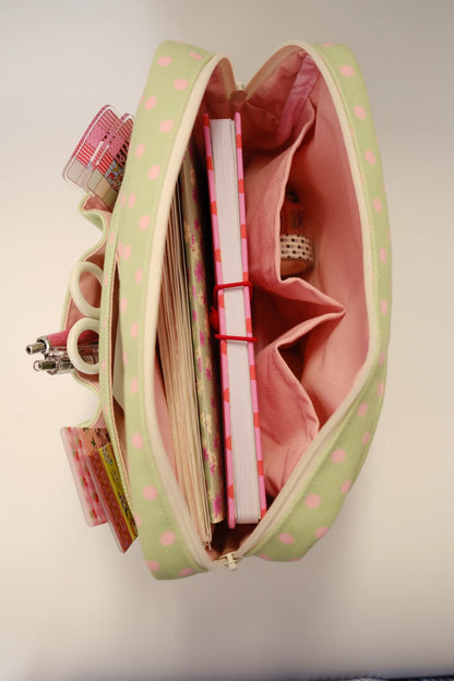 Green polka dot crafting pouch open with fabric pen slots and pink compartments