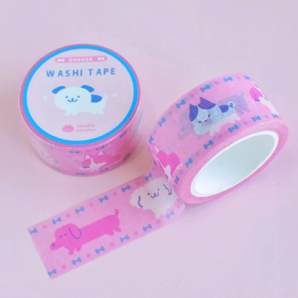 Pink washi tape roll with cute dog prints and unspooled decorative strip